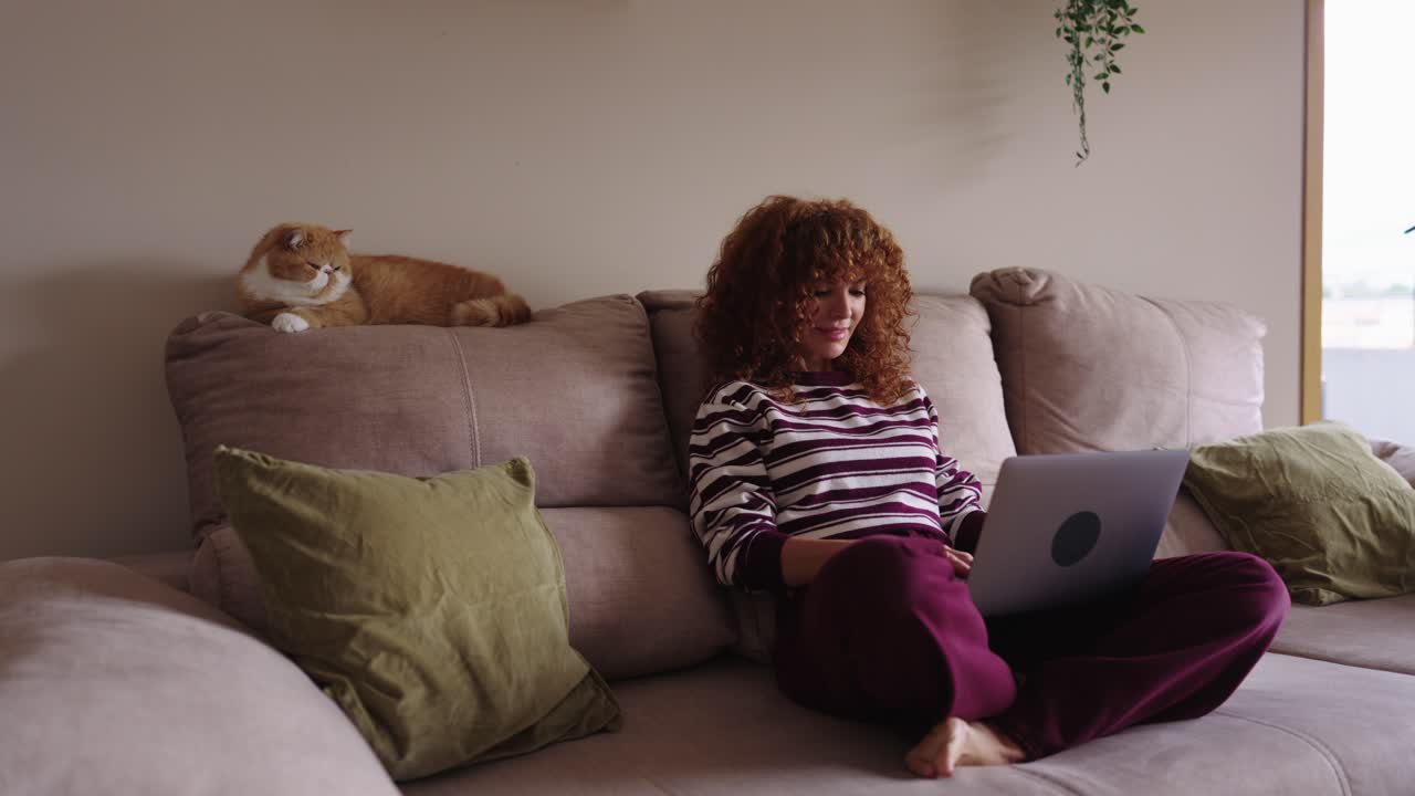 Kvinde med bærbar og kat i sofaen