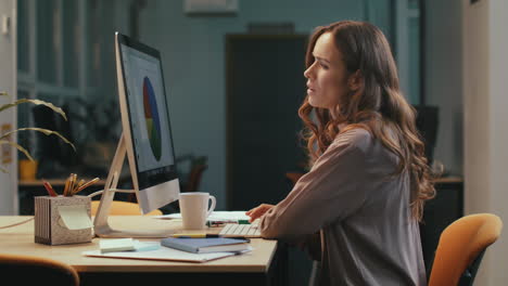 mujer de negocios trabajando hasta tarde en la oficina. mujer seria encontrando un error.