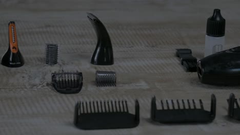 different men's grooming devices like razor, spacer and beard oil on a wooden table