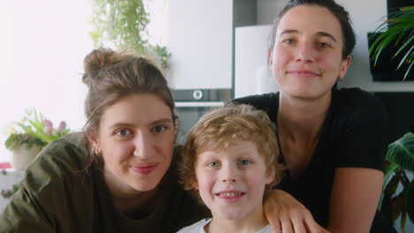 portrait of happy lesbian family with little son at home