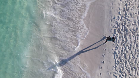 a solo runner jogs on the shoreline while in the caribbean