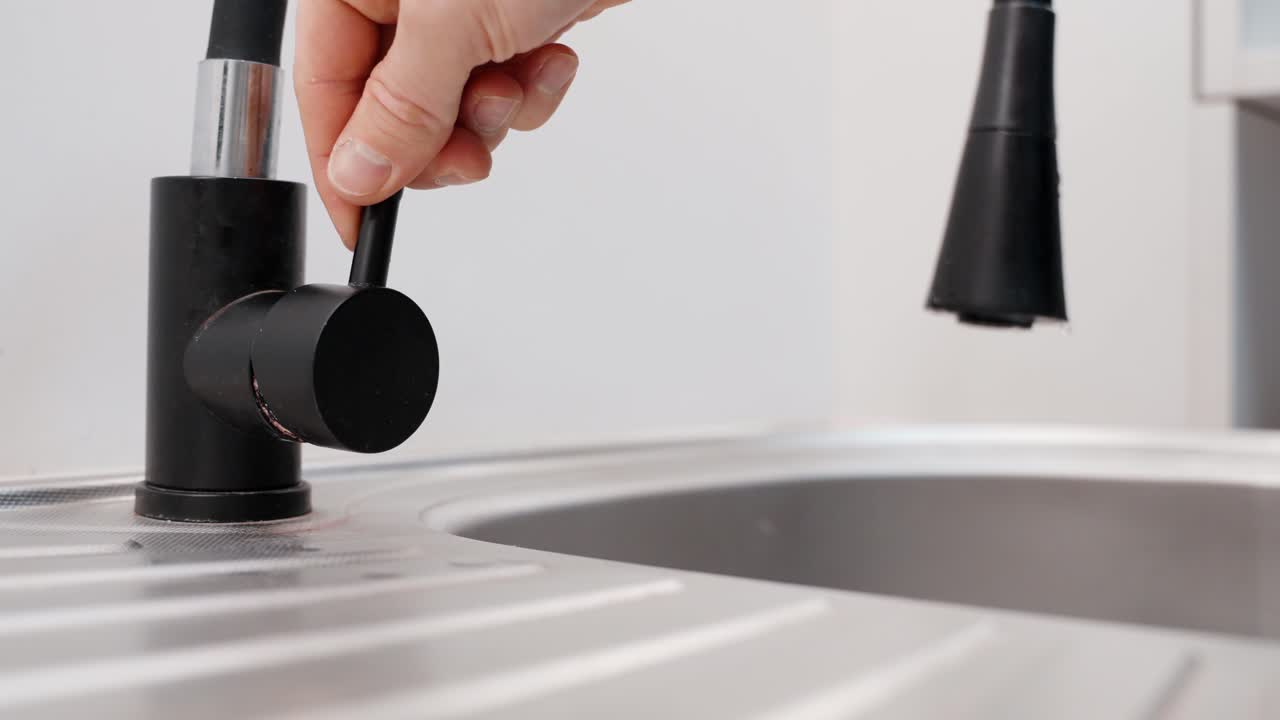 Chiusura dell'acqua da un rubinetto moderno della cucina, vista statica ravvicinata