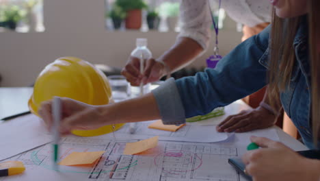 close up architects using building plans business women working together on construction project team of engineers brainstorming design solution planning successful development strategy