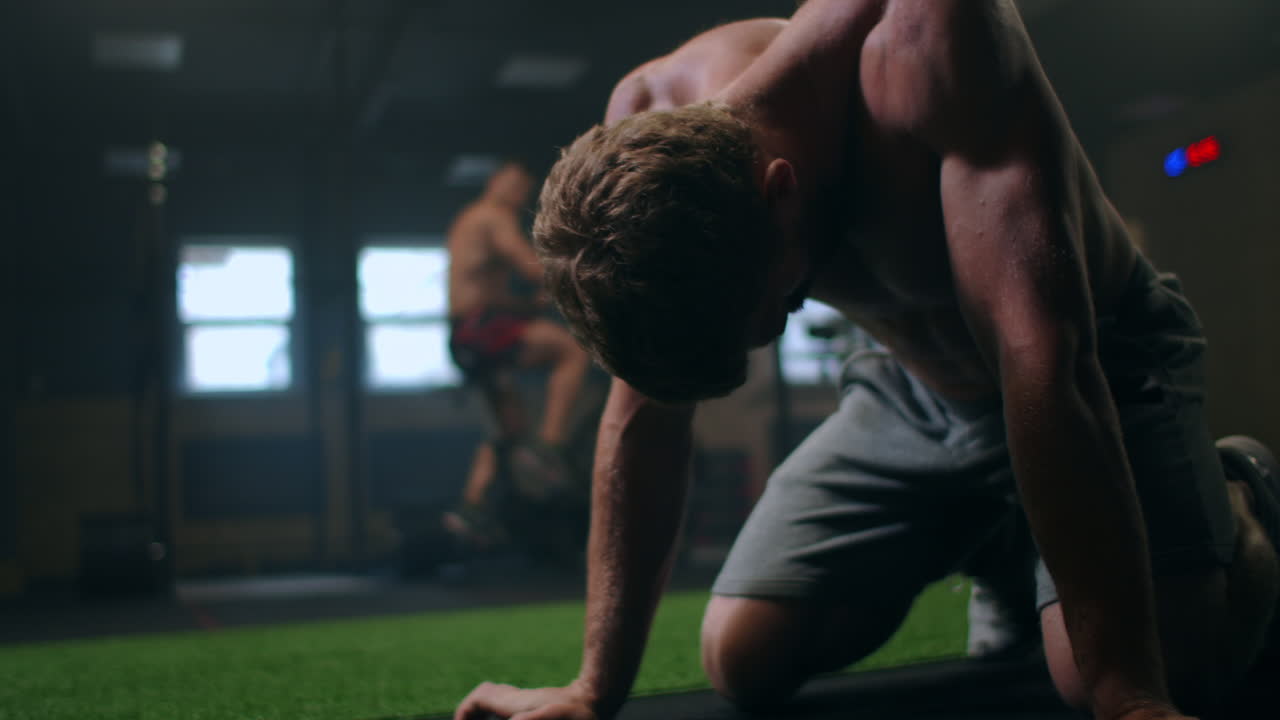 ⁇ 이  ⁇ 고 피곤한 남성 운동선수가 열심히 운동한 후 지친 채 바닥에 앉아 있습니다. 힘을 얻기 위해 휴식을 취하기 위해 휴가. 자신과 몸에 대한 열심한 작업