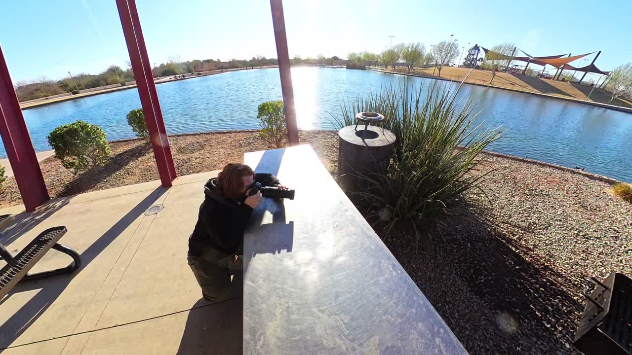Red haired male photographing cormorants at Mansel Crater Park in Queen Creek Arizona.