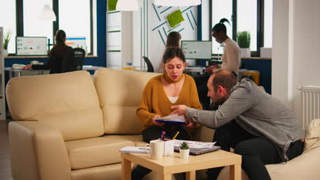 Nervous-businesspeople-yealing-at-each-other-sitting-on-couch