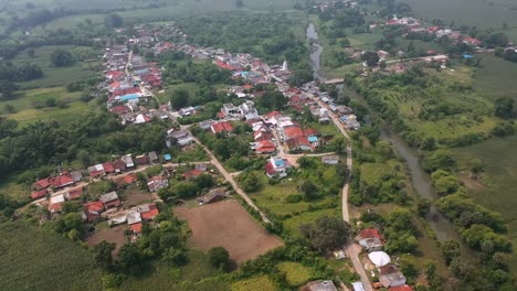 The-footage-captures-the-layout-of-the-village-with-houses,-and-a-surrounding-lush-green-environment