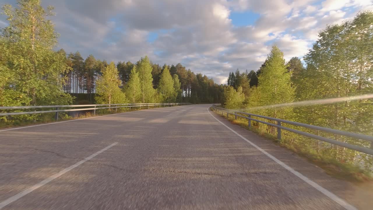 pov를 운전하는 골든 아워: 호수를 지나는 아침 드라이브에서 일출 렌즈 플레어