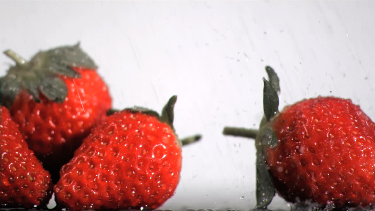Fragole che ricevono gocce al rallentatore