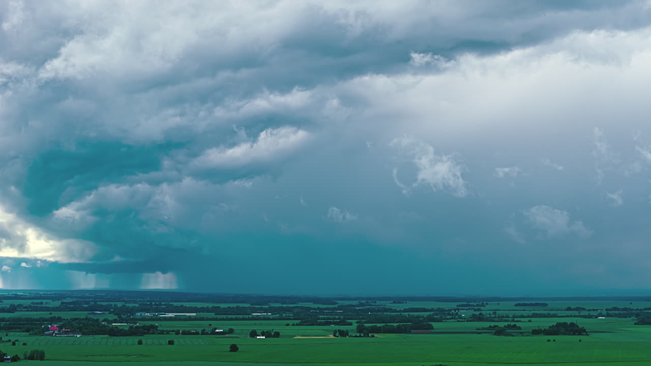 Nimbostratus rain clouds dark grey spread across the sky time lapse rural field