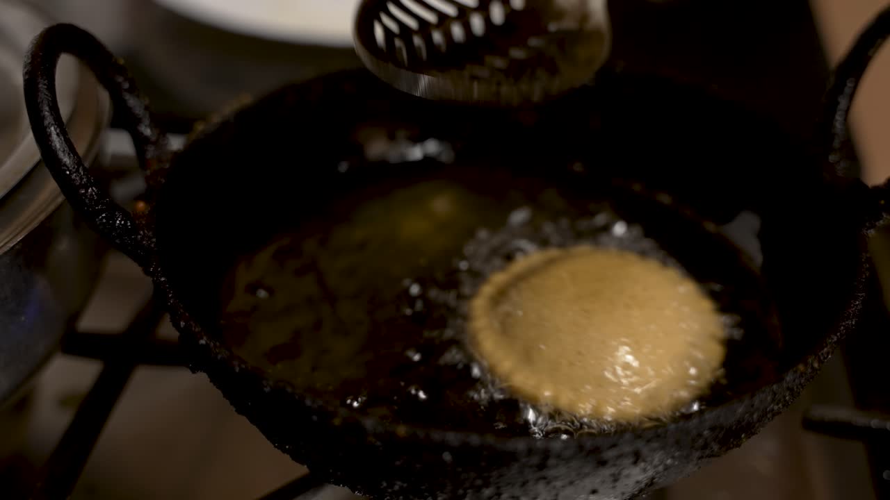 Metal Slotted Spoon Gently Turning Over Floating Fresh Guror Handesh In Pan Filled With Hot Oil