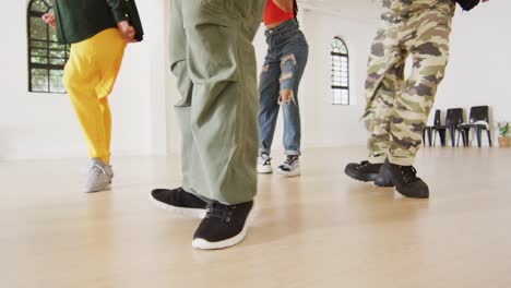 low section of diverse male and female dancers dancing in dance studio, slow motion