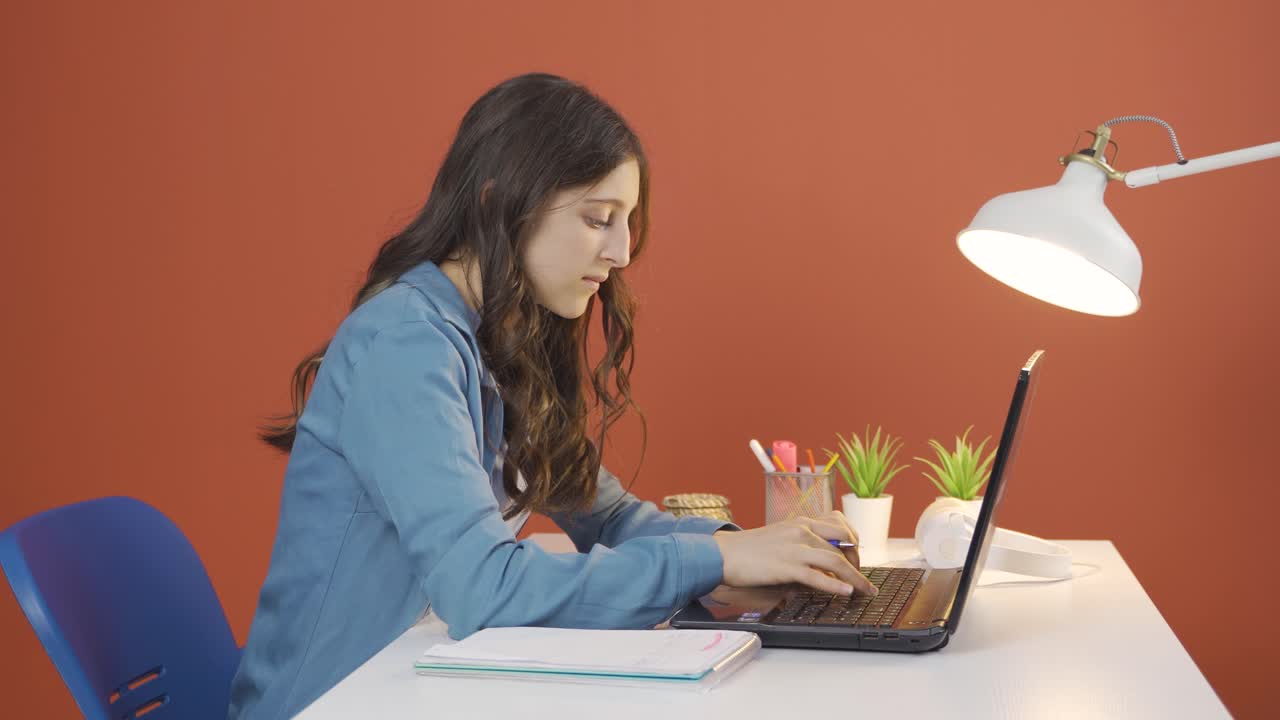 mujer joven concentrada trabajando en una computadora portátil.