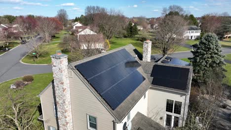aerial drone orbit around home with chimney and solar panels on roof