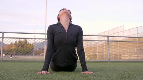 fit female performs downward dog to hindu pushup yoga stretch