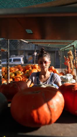 woman selling pumpkins at a fall market