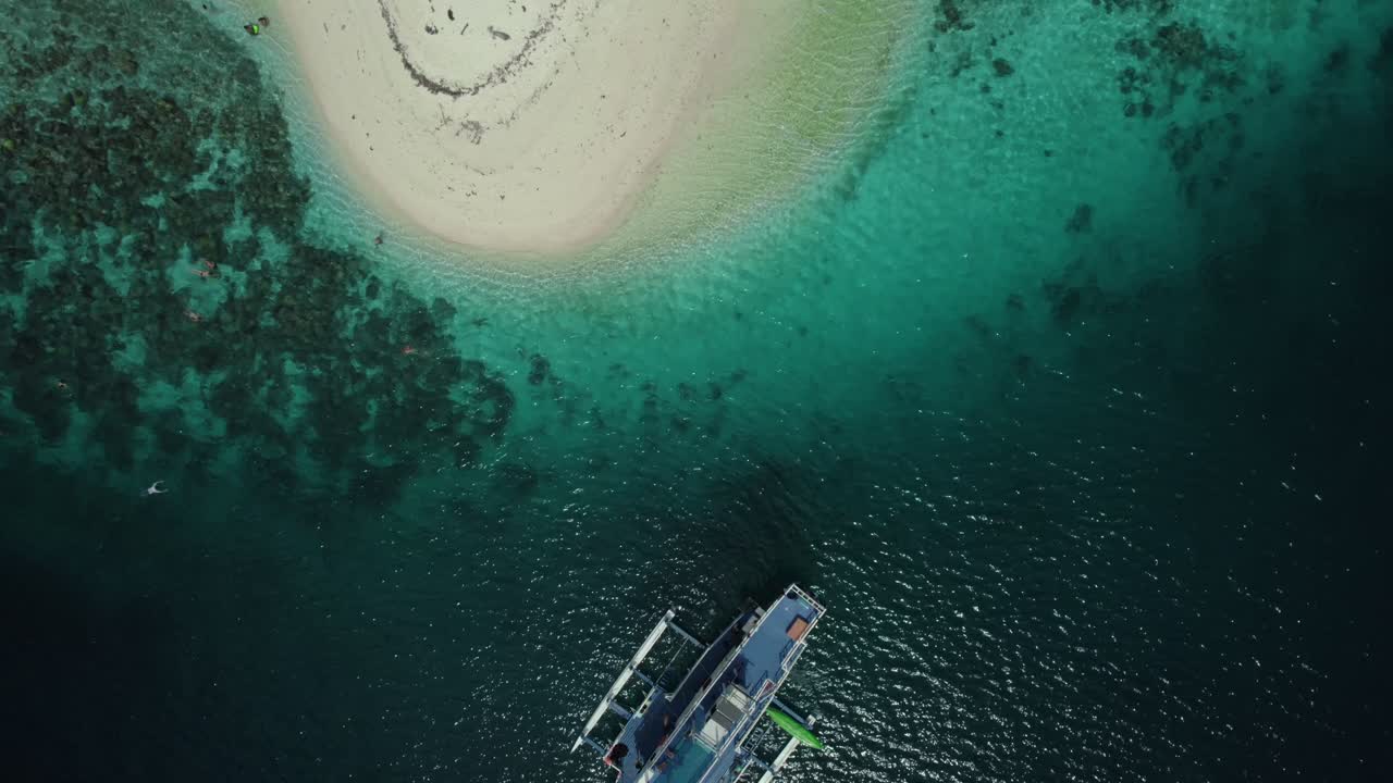 Aerial shot zooming down on boats in the water in the stunning scenic island of the Philippines