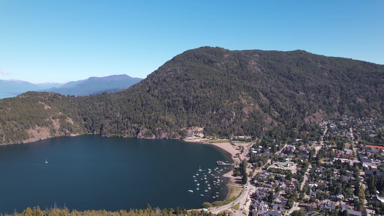4K drone aerial view of San Martín de los Andes, Neuquén, Argentina. The city sits on the shores of Lake Lácar, surrounded by lush green mountains and the spectacular landscapes of northern Patagonia.