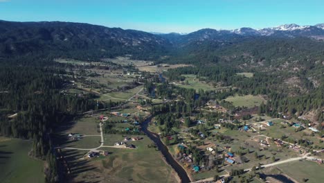 aerial view of town houses between the river with panorama of mountains