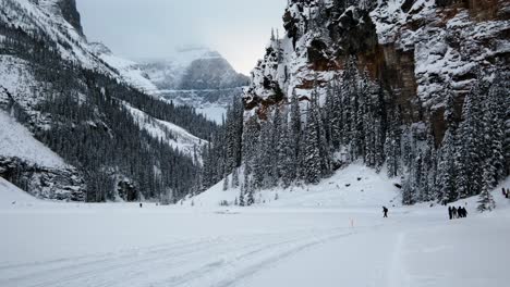 tourists trekking in the banff national park with snow capped rocky mountains and forests