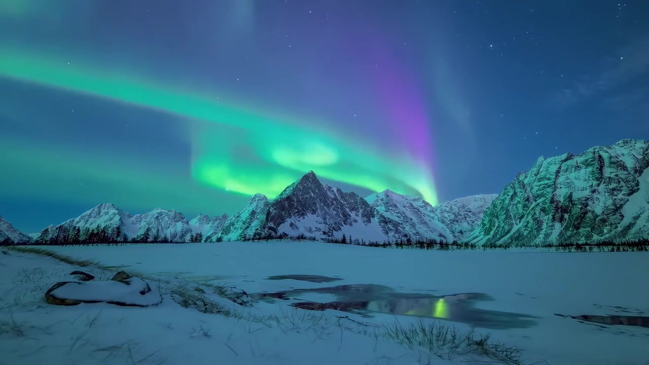 Vivace Aurora Boreale su Paesaggio Montano Innevato