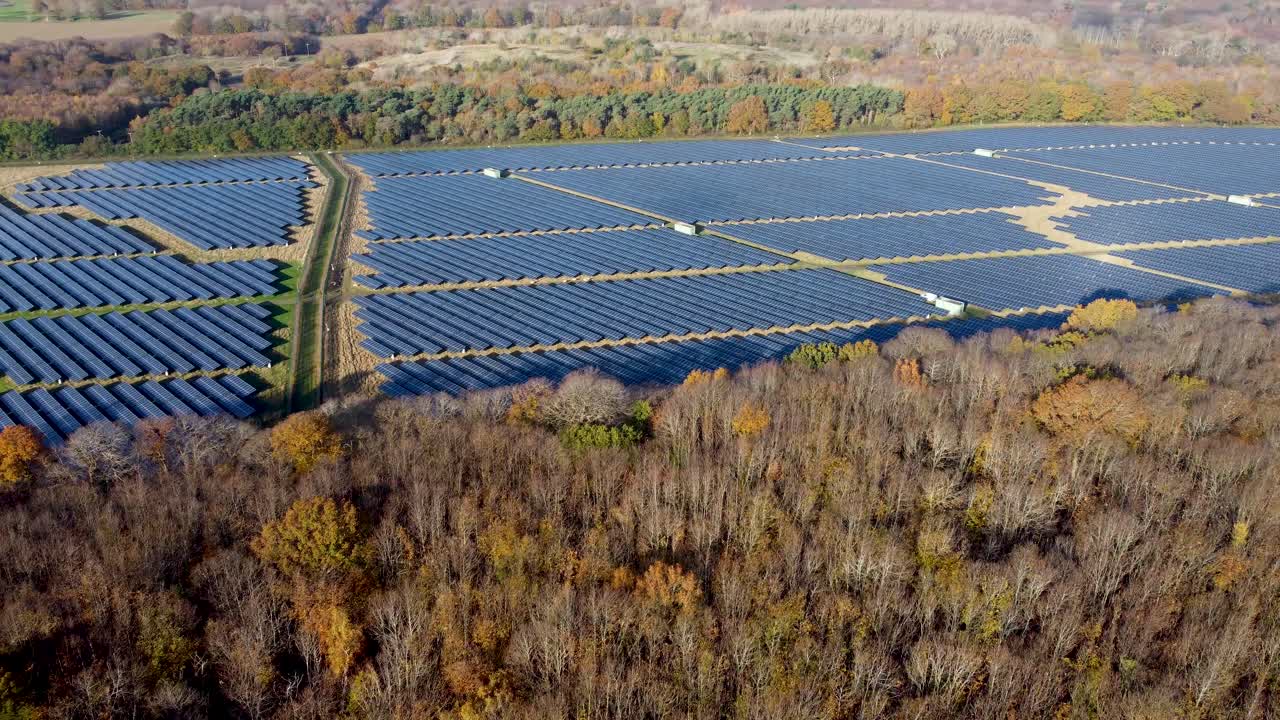 солнечная ферма в великобритании с осенними деревьями на переднем плане кукла вперед панорамирование вправо