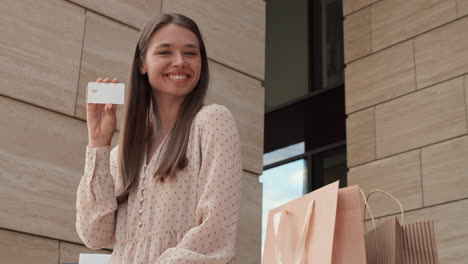 woman posing with credit card outside