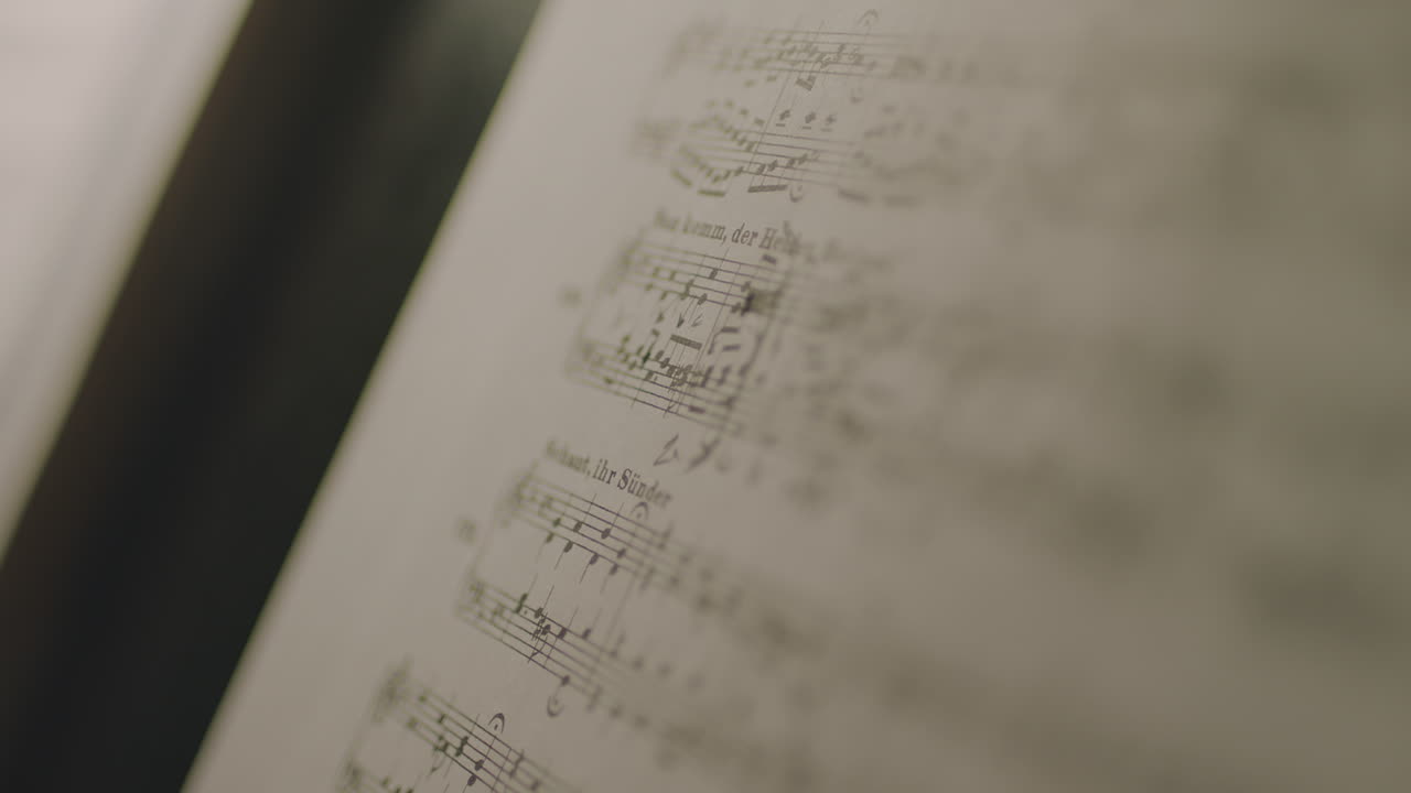 Person writing musical notes in a book