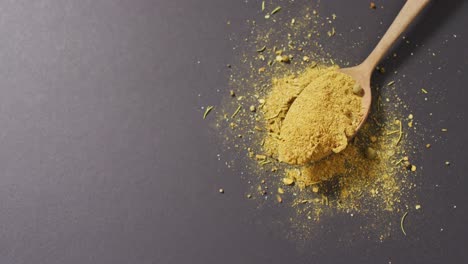 video of spoon with tumeric seasoning lying on grey surface