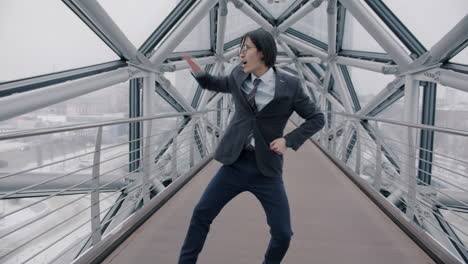 un hombre de negocios bailando en un puente de la ciudad.