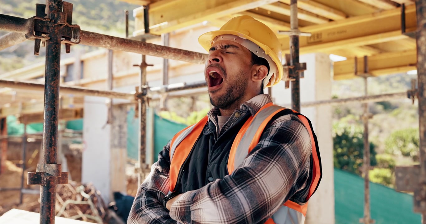 Tired Construction Worker Yawning on Building Site