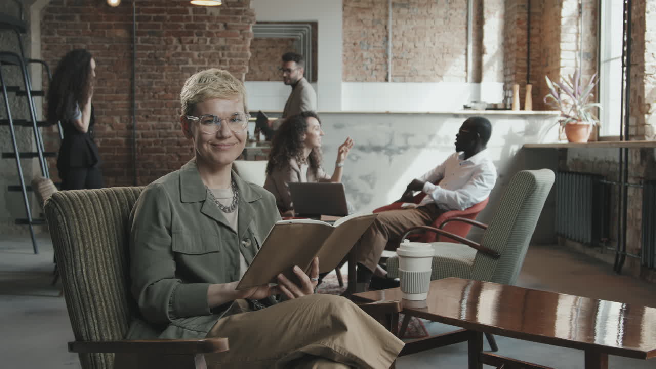 Businesswoman Looking through Planner and Posing for Camera