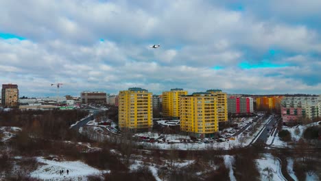 aerial sideway motion of colorful apartment buildings with plane in sky, prague