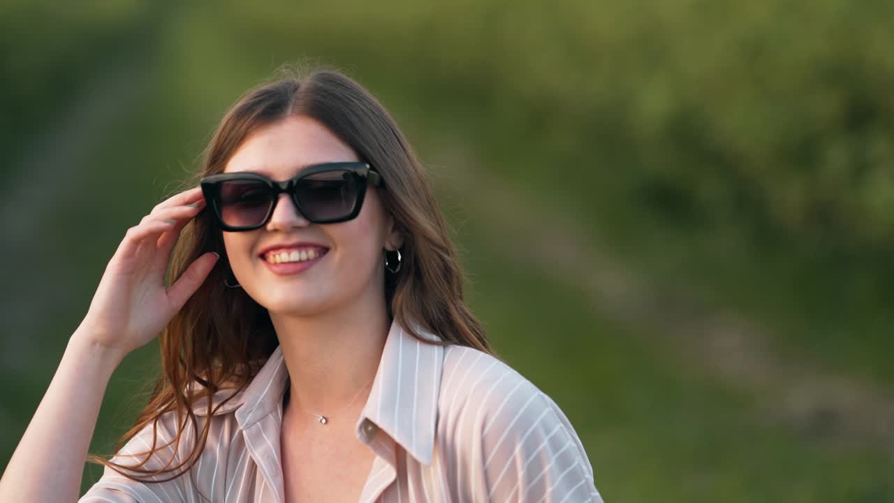 close-up portrait of a young woman wearing sunglasses on nature