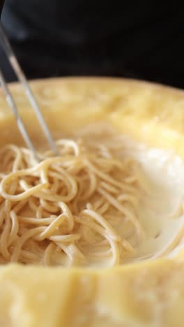 cooking creamy pasta in a cheese wheel