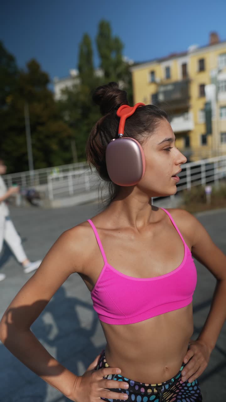 mujer joven en traje de entrenamiento con auriculares