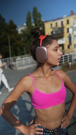 young woman in workout outfit with headphones