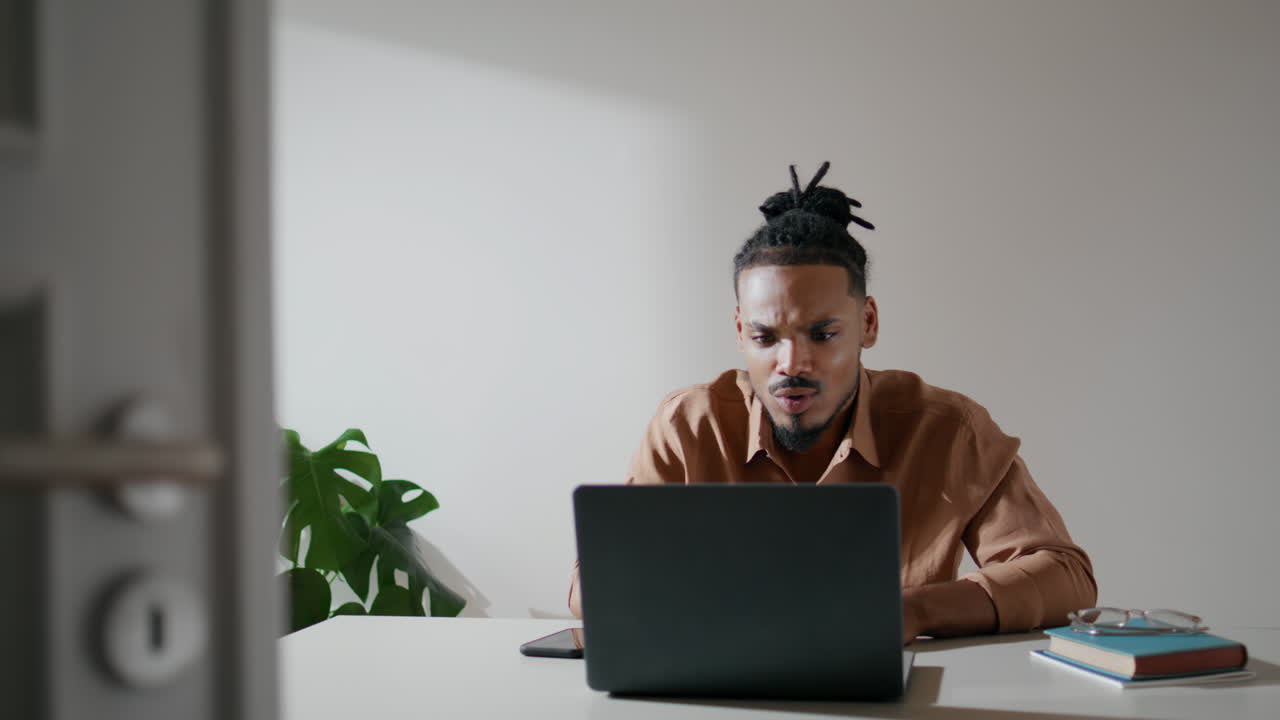 Friendly freelancer explaining laptop home closeup. African american man talking