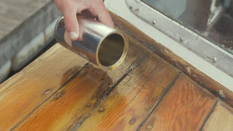 pouring wood hardener treating affected timber planks with wood rot