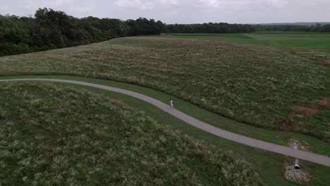 aerial drone view, walking down path near farm grassland
