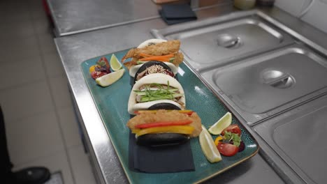 plato de pan bao con carne y verduras, chef con guantes negros sirviendo comida