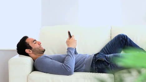 Man-texting-laid-on-the-couch