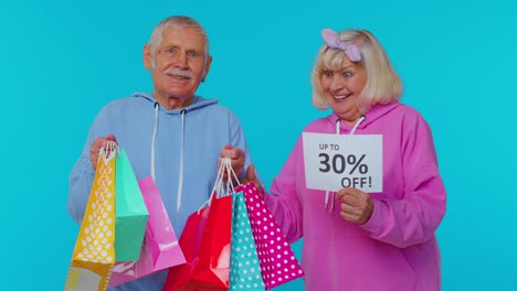 Senior-grandparents-showing-shopping-bags-and-Up-To-30-Percent-Off-banner-text,-Black-Friday-holiday