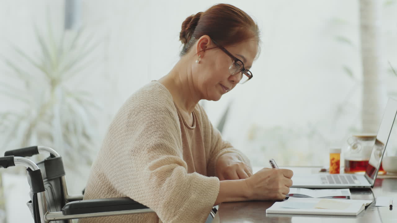 Elderly woman working on paperwork at home