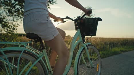 Seitenansicht-Einer-Nicht-Wiederzuerkennenden-Kaukasischen-Frau,-Die-Bei-Sonnenuntergang-Auf-Der-Dorfstraße-Fahrrad-Fährt.