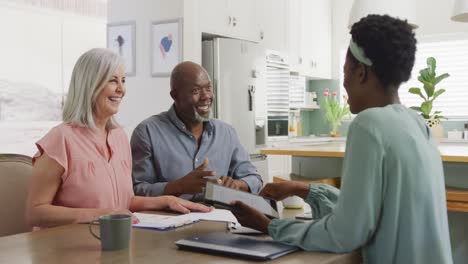 happy senior diverse couple with african american female friend talking about work