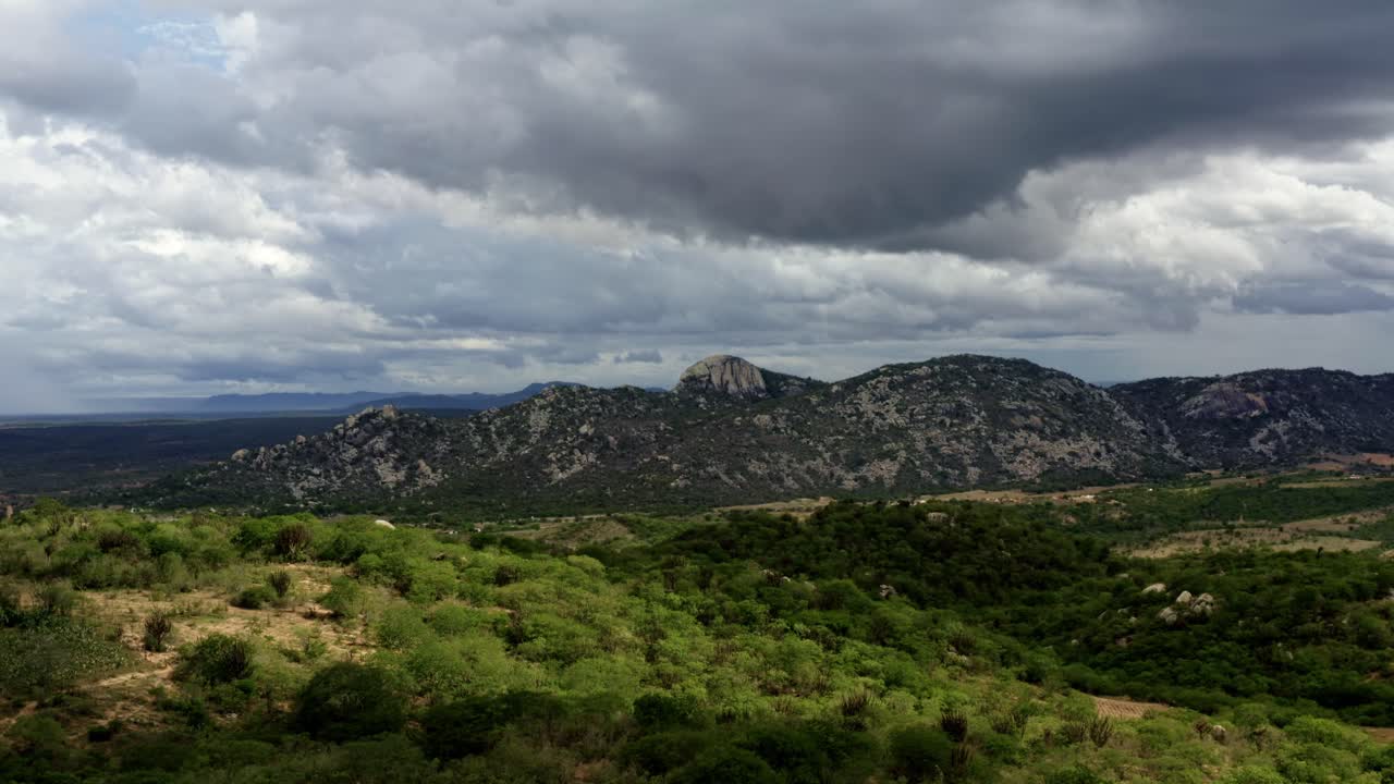 dron aéreo descendente plano amplio extremo de la cordillera de la pedra de sao pedro en sítio novo, brasil en el estado de rio grande do norte durante un nublado y tormentoso día de verano