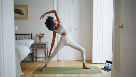 Flexible-Frau,-Die-Ihren-Körper-An-Einem-Gemütlichen-Ort-Streckt.-Athletin-Mit-Lockigem-Haar-übt-Asana