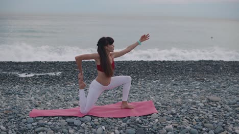 woman practicing yoga on a beach