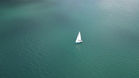 Barco-De-Papel-Como-Un-Yate-Solitario-Navegando-En-El-Fondo-De-La-Naturaleza-Del-Agua-Del-Lago-Turquesa